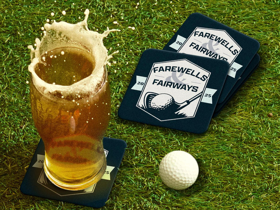 Custom square pulpboard coasters are shown sitting on a grassy, green golf course next to a pint of beer and a white golf ball. The pint of beer has a golf ball splashing into it and has a coaster underneath it. The coaster features design with an illustration of a golf ball and with club behind it and custom text.