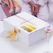 White gift box wrapped with satin ribbon and finished with a personalized gold foil “Let Your Adventure Begin” wedding gift tag. Elegant wedding gift presentation idea.
