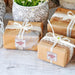 Wrapped wedding gifts with personalized “Your Biggest Fans” tags attached to ribbon and twine. The foil cardstock tags add a polished finishing touch to gift packaging.