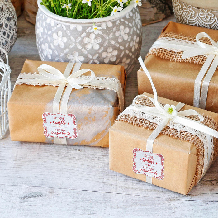 Wrapped wedding gifts tied with ribbon and finished using personalized “Let Love Sparkle” white glitter wedding gift tags. Adds a polished finishing touch to bridal shower and wedding presents.