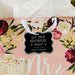 Floral wedding-themed display featuring a personalized “Let Your Adventure Begin” wedding gift tag in metallic foil. Styled with romantic flowers and wedding décor accents.