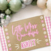 Angled view of the personalized birthday banner highlighting the pink gingham border, flower details, and custom name personalization.