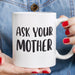 Close-up of hands holding the “Ask Your Mother” ceramic mug with a casual denim outfit in the background. A simple lifestyle image showing the mug as a fun everyday gift.