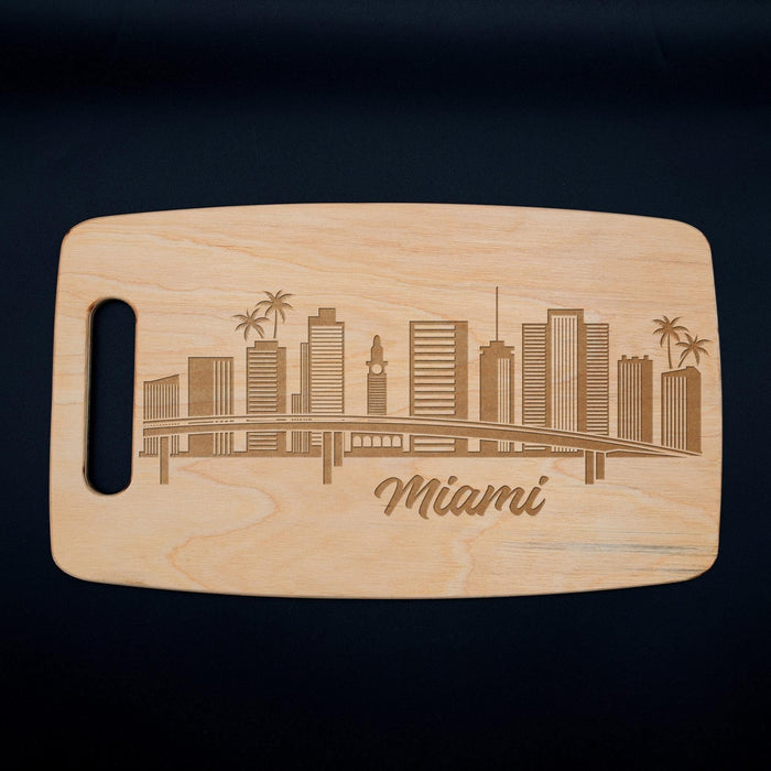 Full view of the Miami skyline cutting board on a dark background with the laser engraved city design clearly visible.