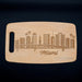 Full view of the Miami skyline cutting board on a dark background with the laser engraved city design clearly visible.