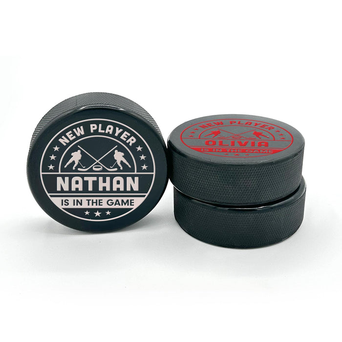 Two personalized hockey pucks showing the UV printed birth announcement design from the front and an alternate printed side.