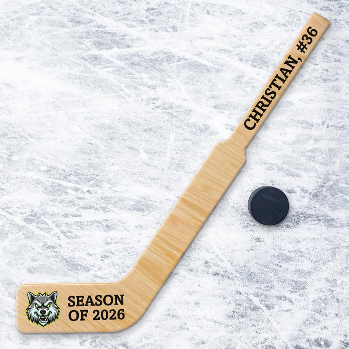 Personalized goalie hockey stick displayed on an ice surface with custom player name, number, season text, and team logo printed on the stick.
