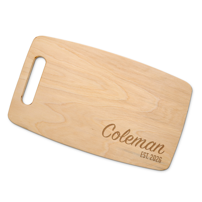 A natural maple cutting board with the name "Coleman EST. 2026" engraved on it.