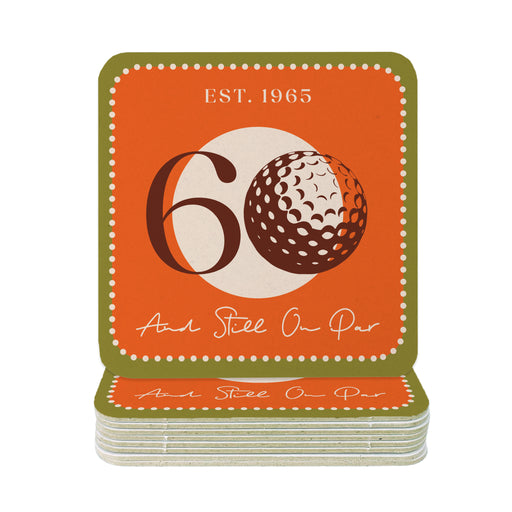 A stack of orange coasters with the number 60 and a golf ball graphic on them, along with the text "EST. 1965" and "And Still On Par" printed on them.