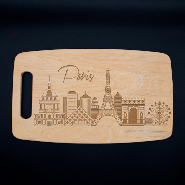 Full view of the Paris skyline cutting board on a dark background with the laser engraved city design clearly visible.