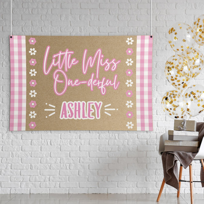 Styled display of the ONE-derful birthday banner showing the butcher paper texture, pink color palette, and playful first birthday theme.