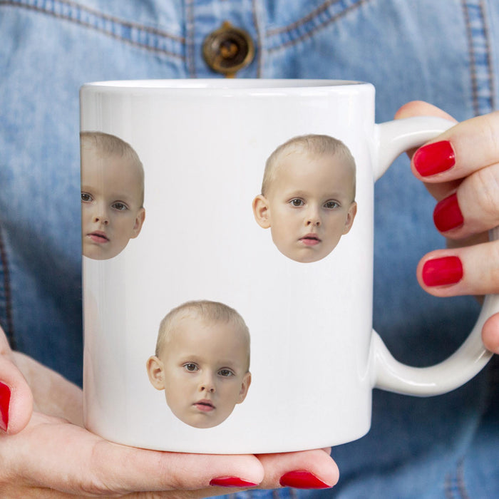 Custom kids face mug held in hand showing multiple grandchild photos.