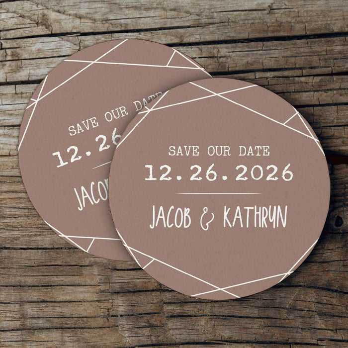 Custom Save the Date coaster displayed on a rustic wood background. Features a clean geometric border design with personalized details.