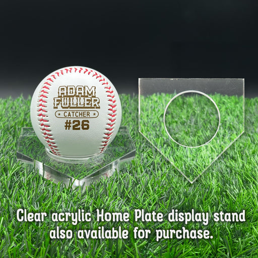 A personalized baseball with red stitching is placed on a clear acrylic stand, accompanied by a text overlay that reads Clear acrylic Home Plate display stand also available for purchase.