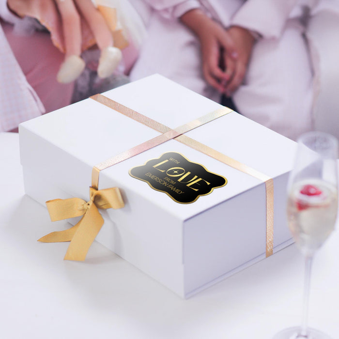 White gift box wrapped with satin ribbon and decorated using a personalized “With Love” gold foil wedding gift tag. A premium wedding gift presentation idea for bridal showers and receptions.