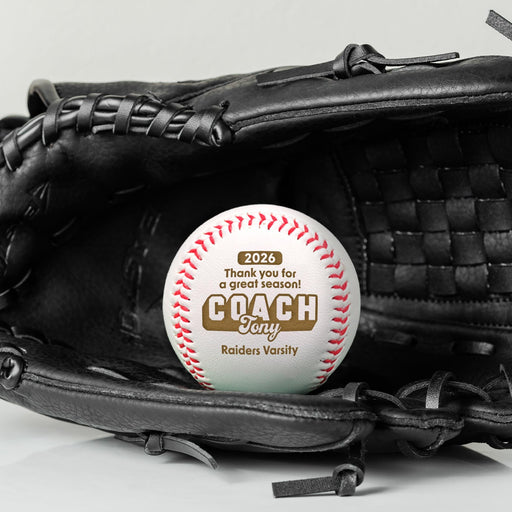 A baseball with a personalized message is placed inside a black baseball glove.