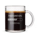 A glass mug filled with a dark liquid, likely coffee, with the text "MOTIVATION LOADING" engraved on it.