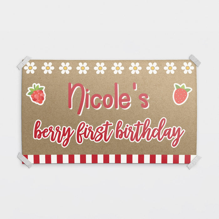 Personalized berry first birthday banner printed on brown butcher paper with strawberry graphics, daisy accents, and custom name design in red lettering.