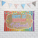 Rainbow birthday backdrop displayed against a white brick wall showing the printed butcher paper material and bright multicolor design.