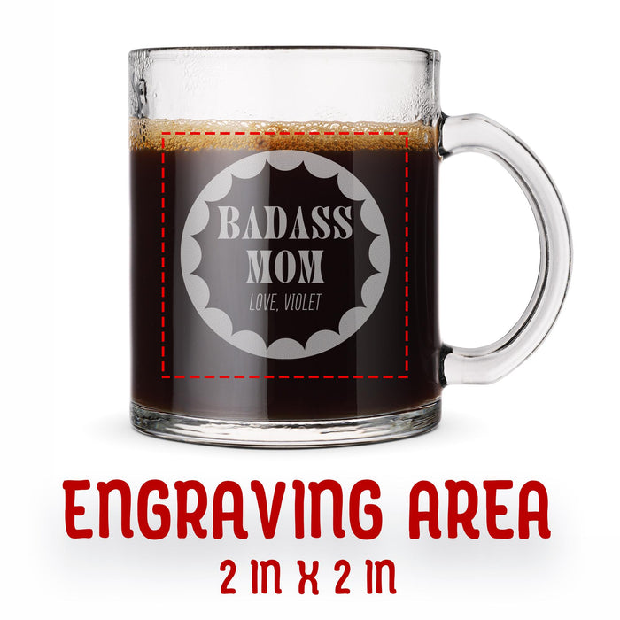 A glass mug with an engraved design on it. The mug is filled with tea, and there is text under the mug that reads "Engraving Area is 2 in x 2 in”