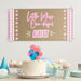 First birthday dessert table setup featuring a custom Little Miss ONE-derful banner displayed above a birthday cake and party decorations.