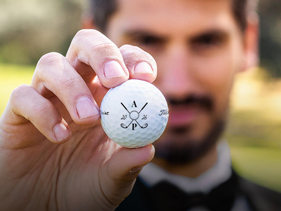 Groom holds Titleist golf ball with Wedding Ring design.