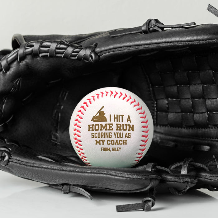 A baseball with the text "I Hit a Home Run Scoring You As My Coach From, Riley" is placed inside a black baseball glove.