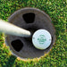 Top view of a personalized retirement golf ball resting in a golf cup. Features a custom name and retirement year design.