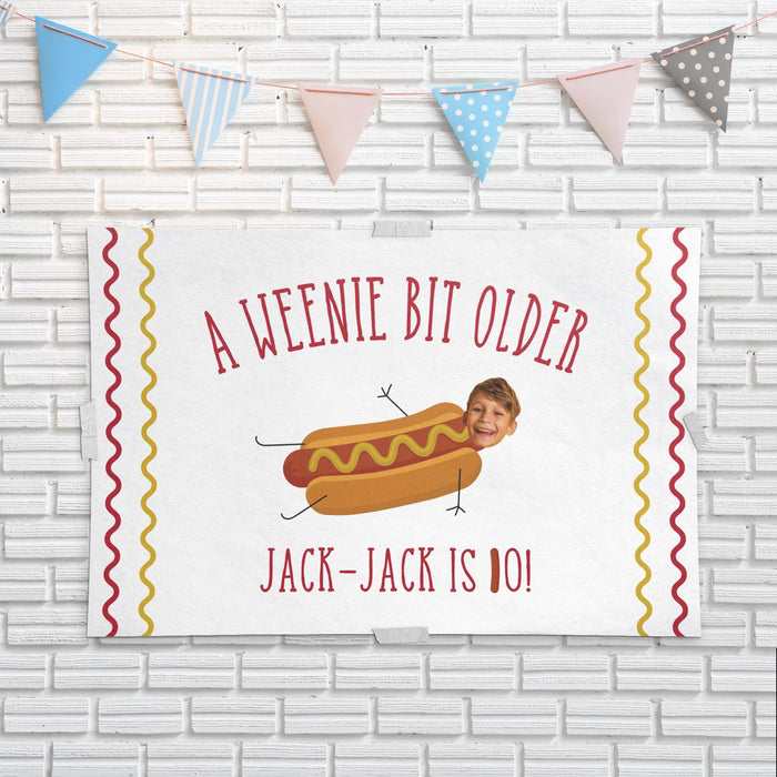 Hot dog birthday banner displayed as wall décor featuring a custom face cutout, name, and age.