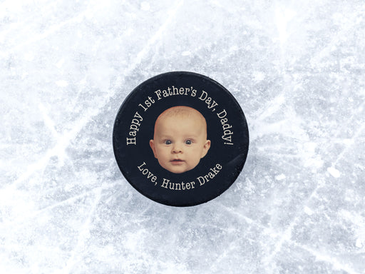 hockey puck on top of ice with a first fathers day baby photo design with the name Hunter Drake printed on it