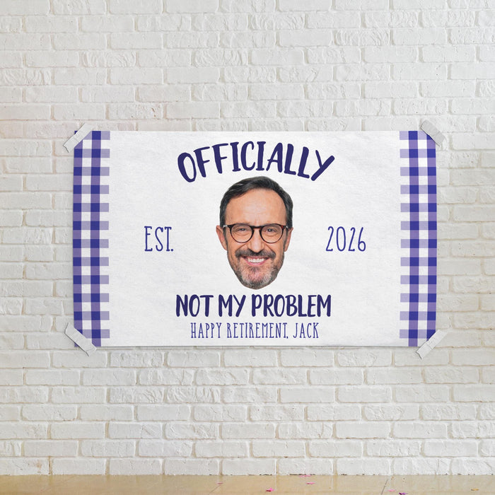 Personalized retirement banner mounted on a white brick wall. Features a custom photo, retirement year, retiree name, and humorous retirement message.
