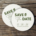 Stack of personalized Save the Date coasters displayed on a rustic wood background. Modern wedding favors customized with names and date.
