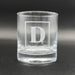 Close-up image of an empty whiskey glass with the framed initial engraving shown clearly. This view highlights the clean etching and overall glass quality.