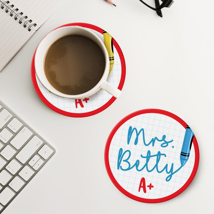 Personalized teacher coaster placed next to coffee and workspace items. Demonstrates practical everyday use.