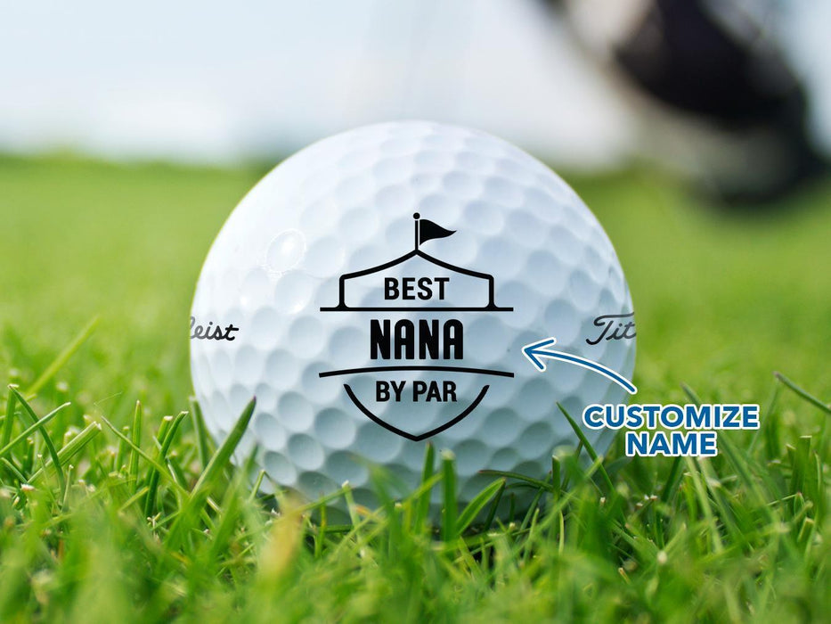 A golf ball with a personalized name on it, placed on a grassy field.