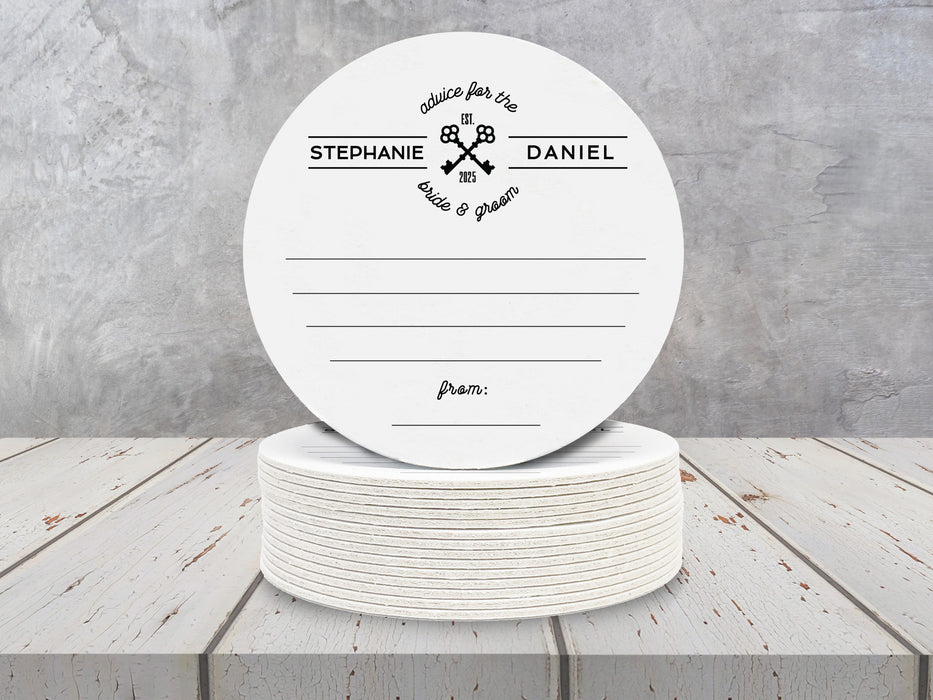 single white coaster ontop of a stack of coasters with personalized custom advice for the bride and groom name coasters ontop of white wooden table in front of gray wall