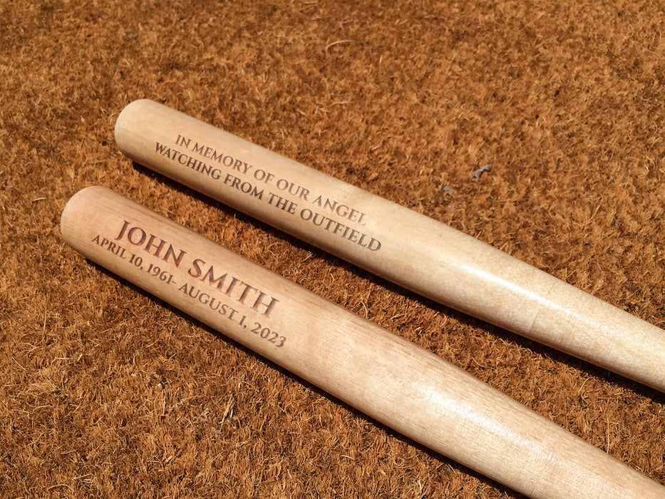 two wooden mini bats with custom text sitting on top of a brown carpet
