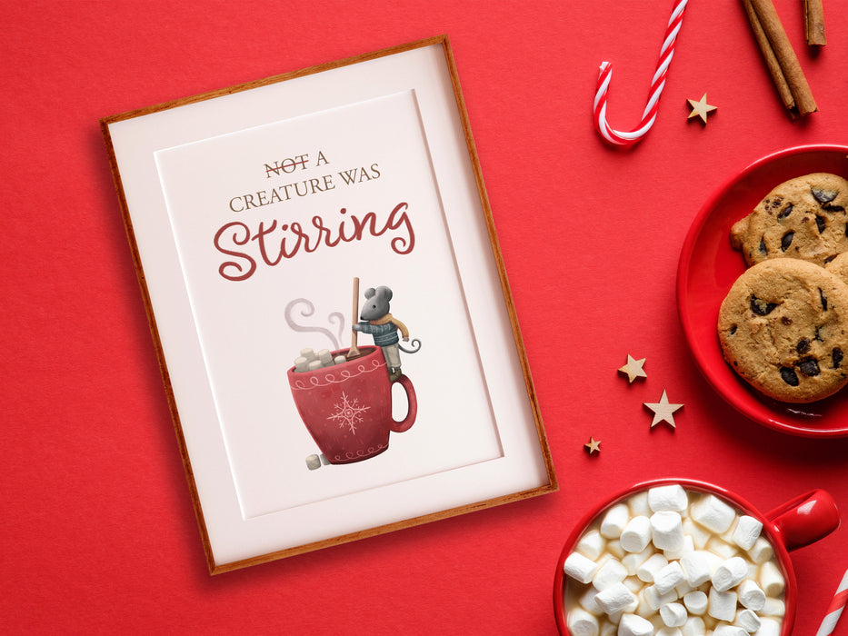 wooden frame ontop of red background with christmas print of mouse stirring hot cocoa surrounded by hot chocolate, chocolate chip cookies, candy canes, cinnamon, and wooden stars, with red plates and mugs
