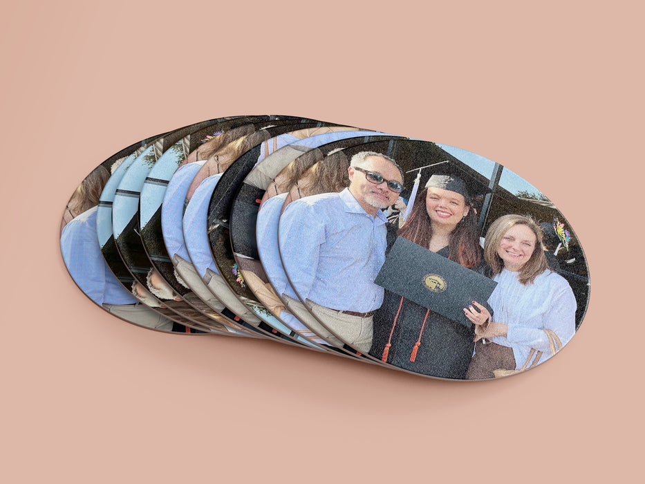 spread stack of paper photo coasters with picture of family graduation event in front of a light pink background