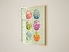 easter print of pastel easter art print of decorated eggs with a baby chick in a gold frame on living room white wall
