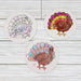 Three Thanksgiving coasters with them flipped over to a turkey drawing. Each is colored in with a different color and style.