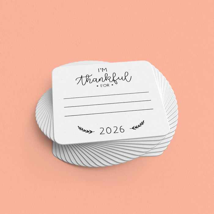 A stack of coasters with black text that reads "I'm Thankful For" on a peach background.