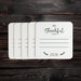White coasters with black text and designs are shown on a dark wood background. The coasters have the text "I'm Thankful for" and "2026" printed on them.