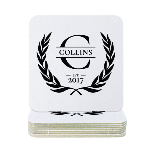 A stack of square white coasters with rounded corners, featuring a black printed monogram design with the word 'COLLINS' inside a laurel wreath and 'EST. 2017' below, shown on a plain white background.