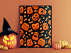 single frame with halloween pumpkin pattern and candy print against orange wall and a countertop with halloween decoration such as decorated pumpkins, a jack o lantern, and a witches hat