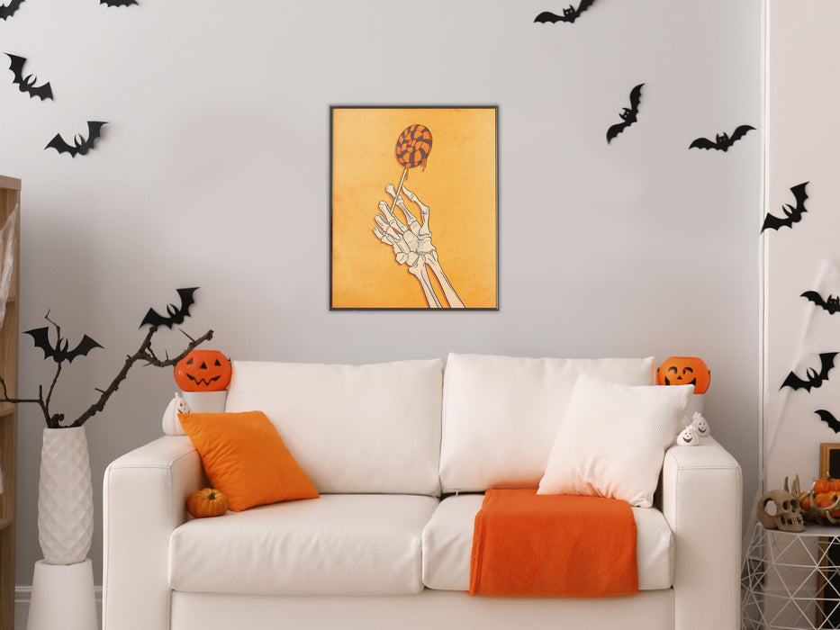 white wall with single frame of orange art of a skeleton hand holding a lollipop with retro vintage textures and patterns, living room with couch with halloween decorations such as bats, pumpkins, orange pillows