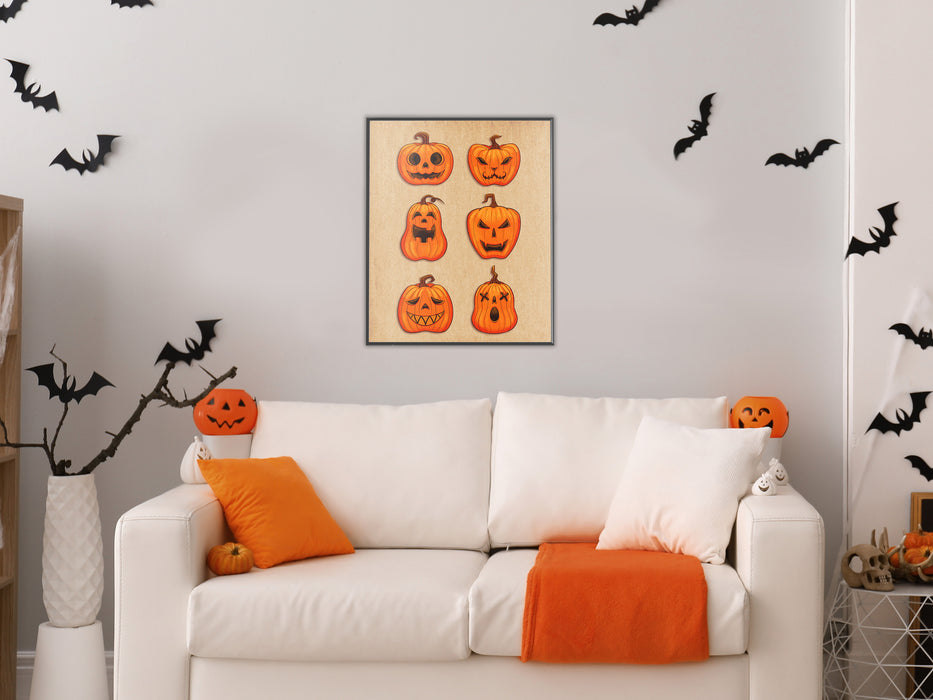white wall with single frame of retro vintage art of a grid of jack o lantern pumpkins with different faces, living room with couch with halloween decorations such as bats, pumpkins, orange pillows