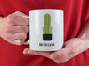 person with red shirt holding white mug with don't be a prick typography design with cactus graphic