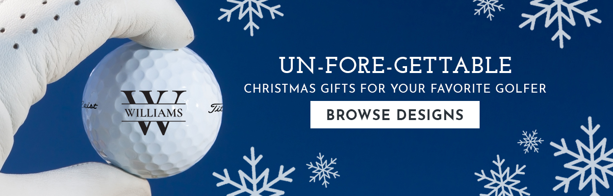 Text: Un-Fore-Gettable, Christmas gifts for your favorite golfer, Browse Designs Image: A white gloved hand is holding a custom Titleist golf ball. The golf ball has the Inital design in black with the name "Williams" printed on it. The background is blue with white snowflakes.