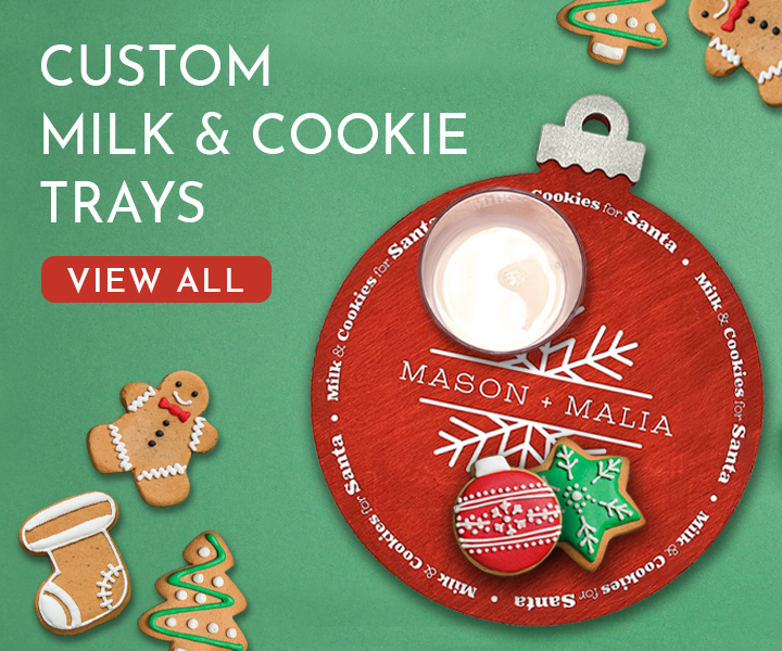 Text: Custom Milk & Cookie trays, View All Image: A red ornament custom milk and cookie tray can be seen on a green background. The tray has a glass of milk and two Christmas cookies on it. Other Christmas cookies can be seen around the tray on the background.